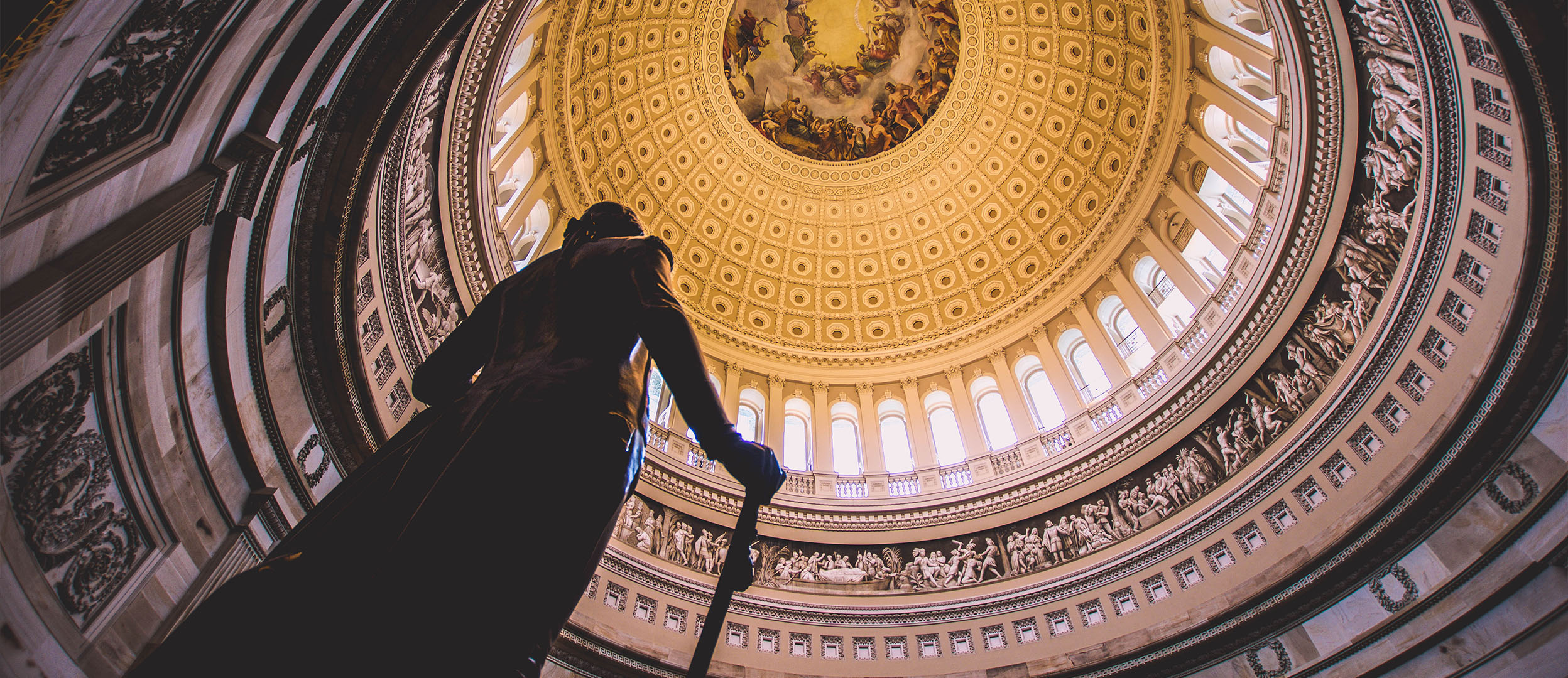 Image of statue inside of court building with golden ceiling